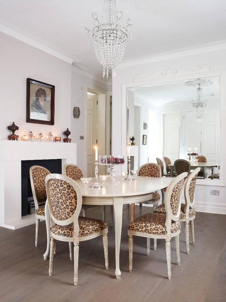 Design ideas for a contemporary separate dining room in Surrey with white walls and brown floor.