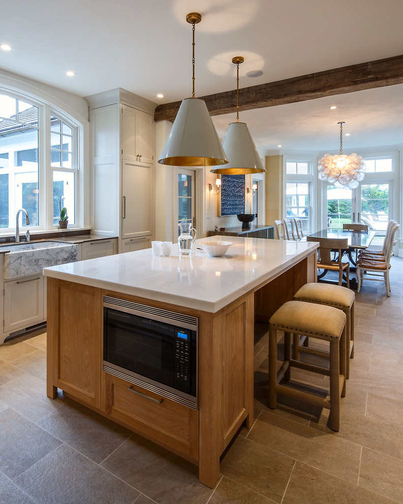 Large transitional galley ceramic tile eat-in kitchen photo in Boston with a farmhouse sink, recessed-panel cabinets, light wood cabinets, quartz countertops, stainless steel appliances and an island