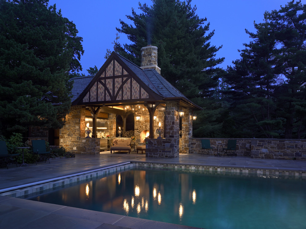 Traditional rectangular pool in Philadelphia with a pool house and natural stone pavers.