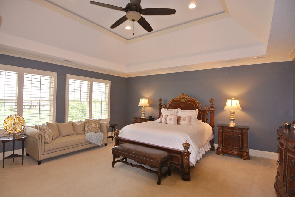 Large traditional master bedroom in Indianapolis with blue walls and carpet.