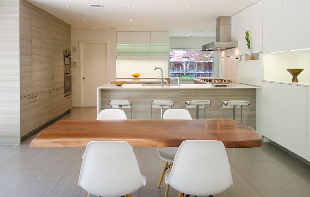Large contemporary u-shaped open plan kitchen in Houston with an undermount sink, flat-panel cabinets, white cabinets, white splashback, panelled appliances, quartz benchtops, light hardwood floors, a peninsula and grey floor.