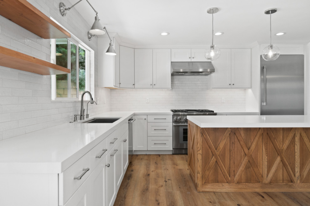 Mid-sized mountain style kitchen photo in Orange County with quartz countertops, gray backsplash, stainless steel appliances, an island and white countertops