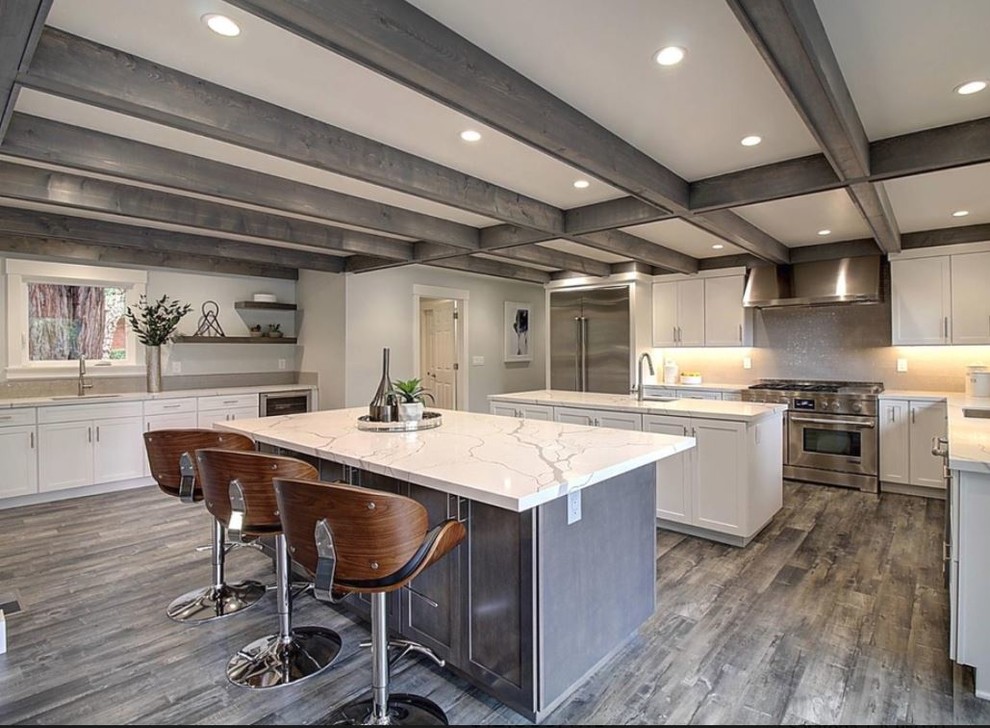 This is an example of a large contemporary u-shaped eat-in kitchen in San Francisco with a single-bowl sink, recessed-panel cabinets, white cabinets, quartzite benchtops, white splashback, mosaic tile splashback, stainless steel appliances, light hardwood floors, no island, grey floor and white benchtop.