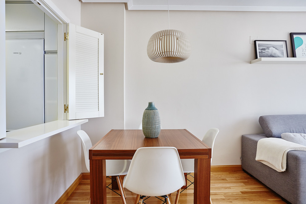 Modelo de comedor actual pequeño abierto con paredes beige, suelo de madera en tonos medios y suelo marrón