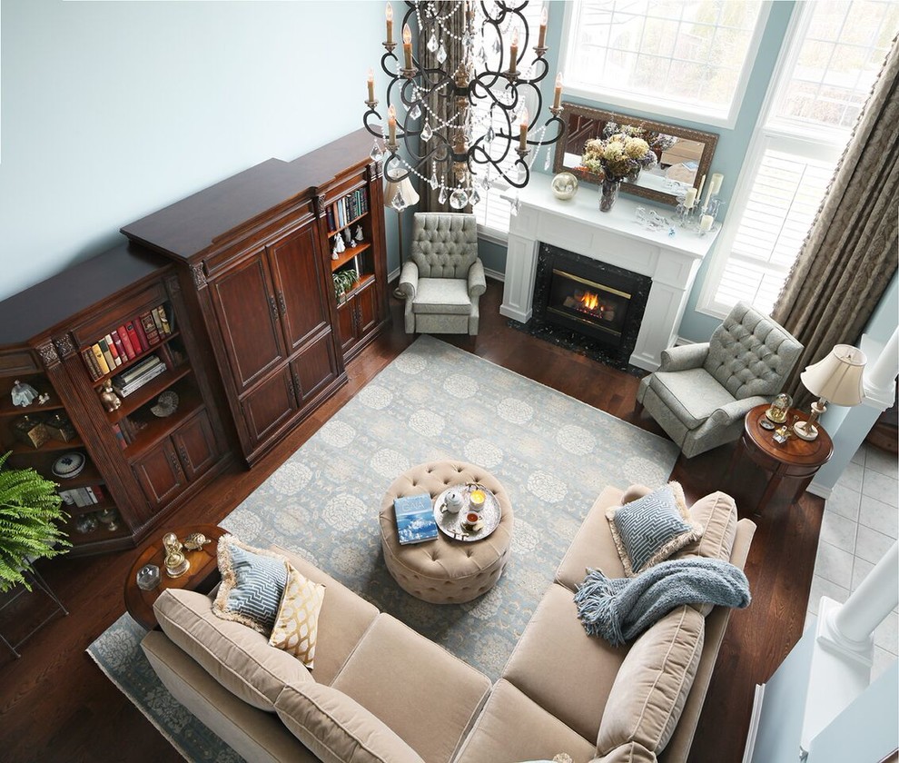 This is an example of a large traditional formal open concept living room in Toronto with blue walls, dark hardwood floors, a standard fireplace, a wood fireplace surround, a concealed tv and brown floor.