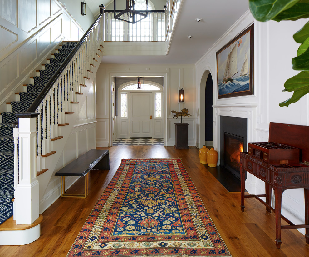 Photo of a mid-sized traditional foyer in New York with white walls, medium hardwood floors, a single front door, a white front door and brown floor.