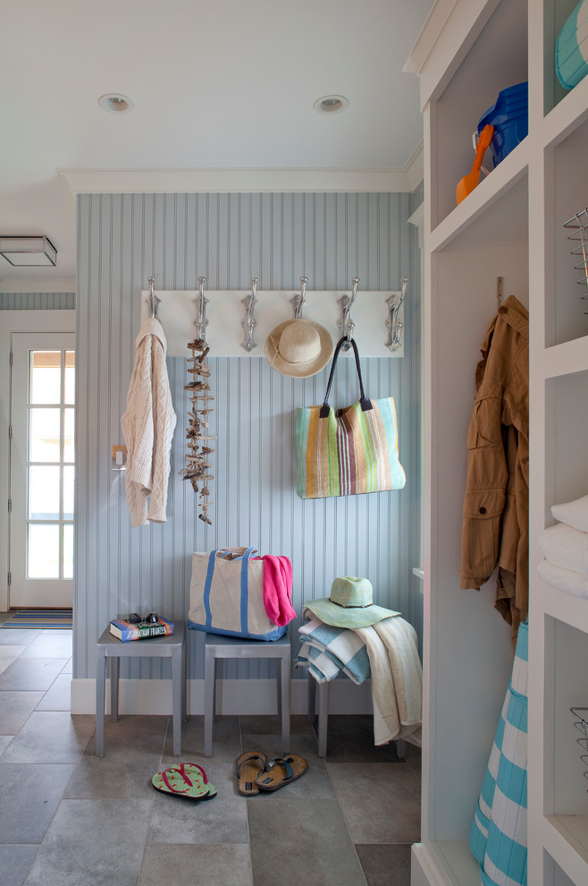 This is an example of a beach style mudroom in Boston with blue walls, a single front door, a glass front door and grey floor.