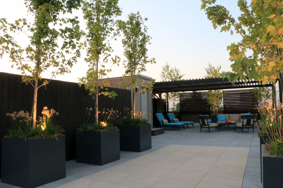 This is an example of a large contemporary rooftop deck in Chicago with a pergola.