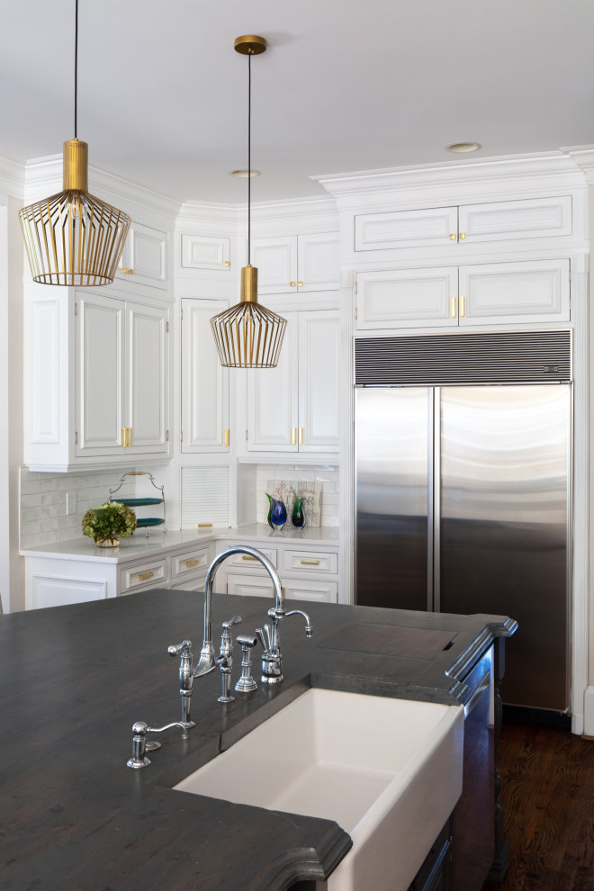 Example of a large transitional u-shaped dark wood floor and brown floor eat-in kitchen design in Atlanta with a farmhouse sink, recessed-panel cabinets, white cabinets, quartz countertops, white backsplash, ceramic backsplash, stainless steel appliances, an island and white countertops