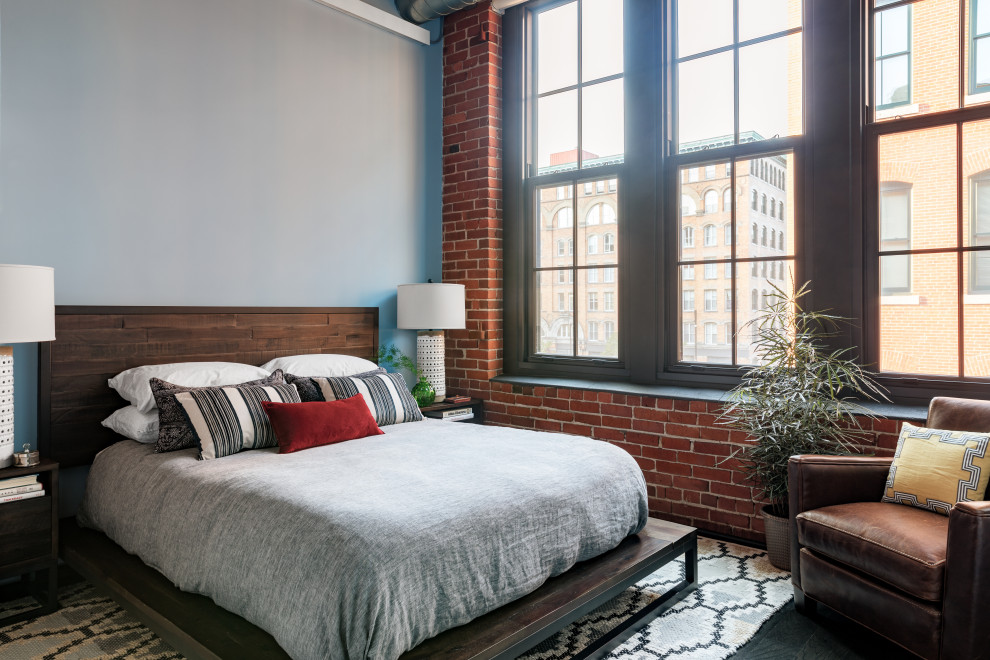 Inspiration for a mid-sized industrial master bedroom in Boston with multi-coloured walls, dark hardwood floors and no fireplace.