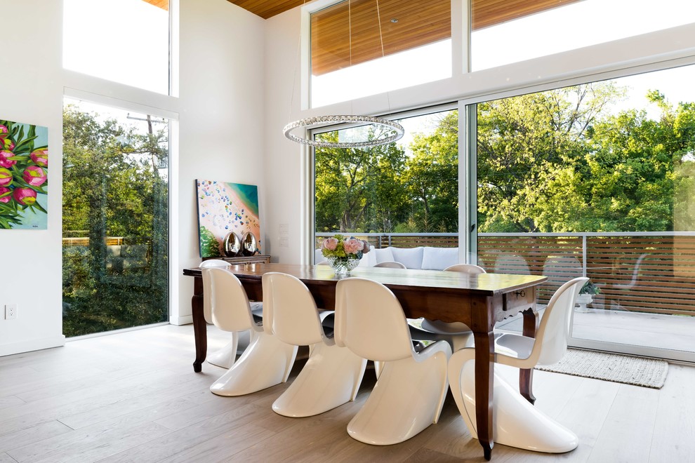 Design ideas for a contemporary open plan dining in Dallas with white walls, light hardwood floors and beige floor.