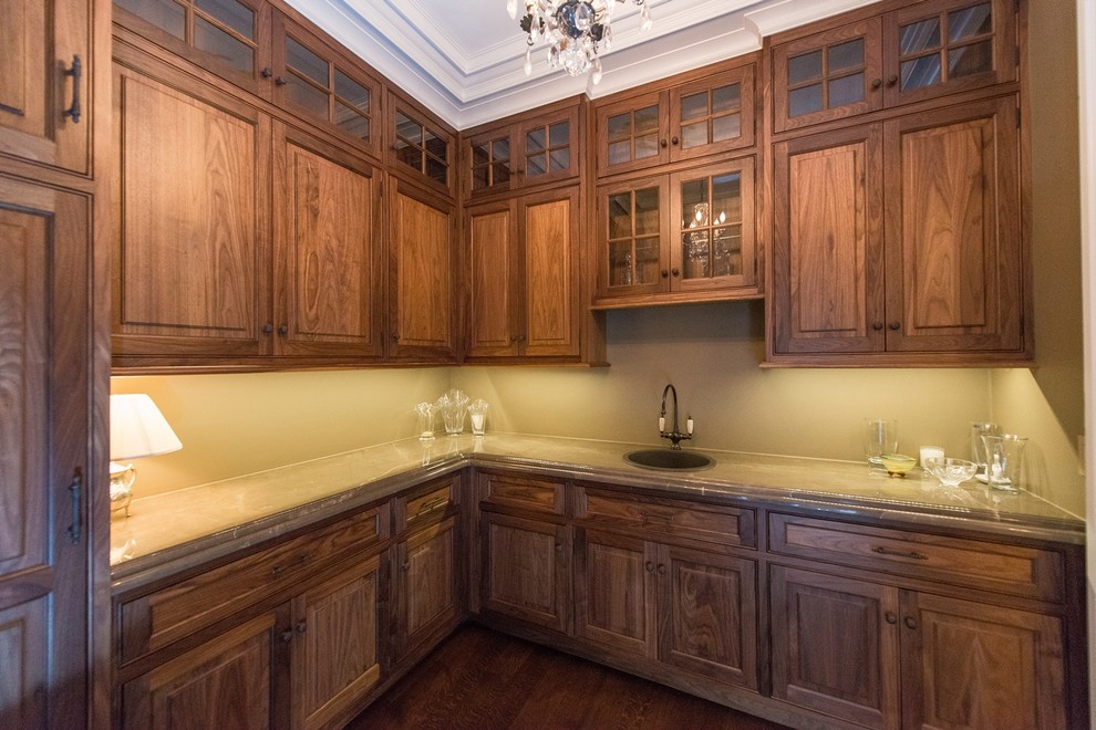 Inspiration for a mid-sized traditional l-shaped kitchen pantry in New York with a drop-in sink, beaded inset cabinets, glass benchtops, dark hardwood floors and no island.