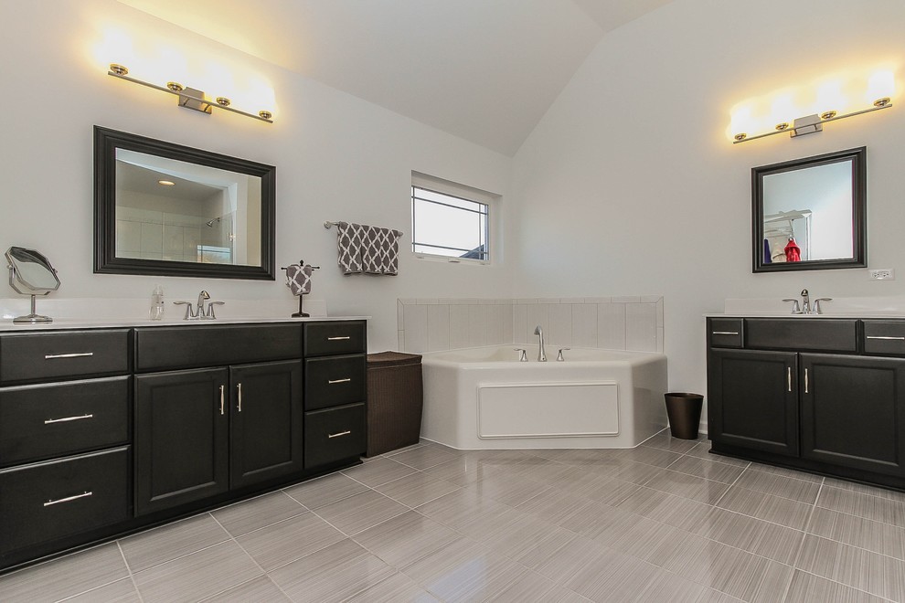 Design ideas for a large modern master wet room bathroom in Chicago with flat-panel cabinets, dark wood cabinets, a corner tub, a two-piece toilet, gray tile, ceramic tile, white walls, ceramic floors, an integrated sink, solid surface benchtops, grey floor and a hinged shower door.