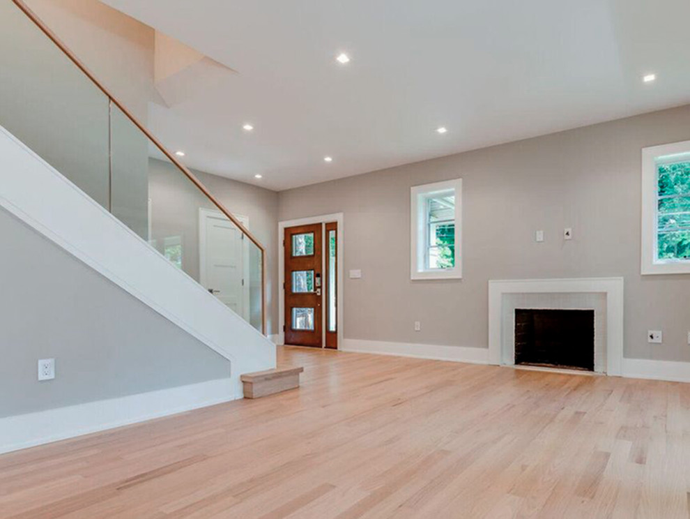 Small contemporary wood straight staircase in DC Metro with wood risers and glass railing.