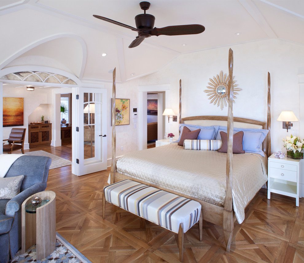 Photo of a beach style bedroom in DC Metro with white walls, medium hardwood floors and brown floor.