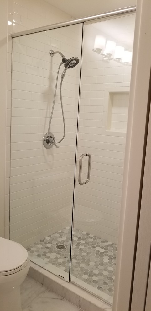 Photo of a medium sized nautical ensuite bathroom in Jacksonville with shaker cabinets, white cabinets, an alcove shower, a two-piece toilet, white tiles, porcelain tiles, white walls, marble flooring, a submerged sink, marble worktops, white floors, a hinged door and white worktops.