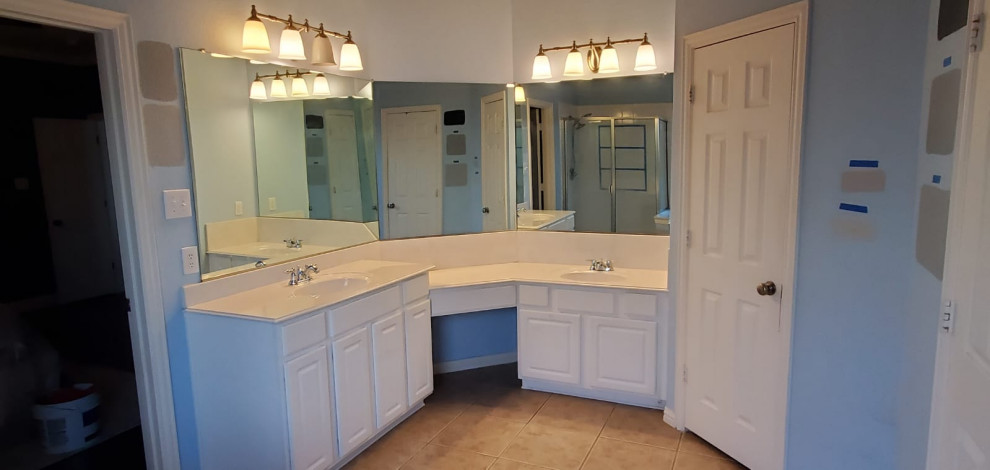 Inspiration for a medium sized modern ensuite bathroom in Dallas with shaker cabinets, black cabinets, a freestanding bath, a corner shower, a two-piece toilet, white tiles, marble tiles, blue walls, ceramic flooring, a submerged sink, grey floors, a hinged door, white worktops, a wall niche, double sinks and a built in vanity unit.