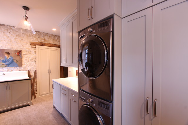 Stacked Washer And Dryer Next To Folding Counter With Marble