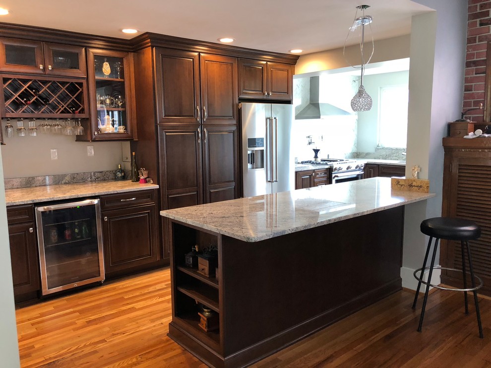 Eat-in kitchen - mid-sized traditional l-shaped light wood floor and brown floor eat-in kitchen idea with an undermount sink, raised-panel cabinets, dark wood cabinets, granite countertops, multicolored backsplash, ceramic backsplash, stainless steel appliances, an island and multicolored countertops