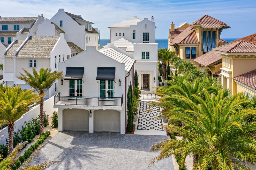 Huge beach style white three-story house exterior photo in Atlanta with a white roof