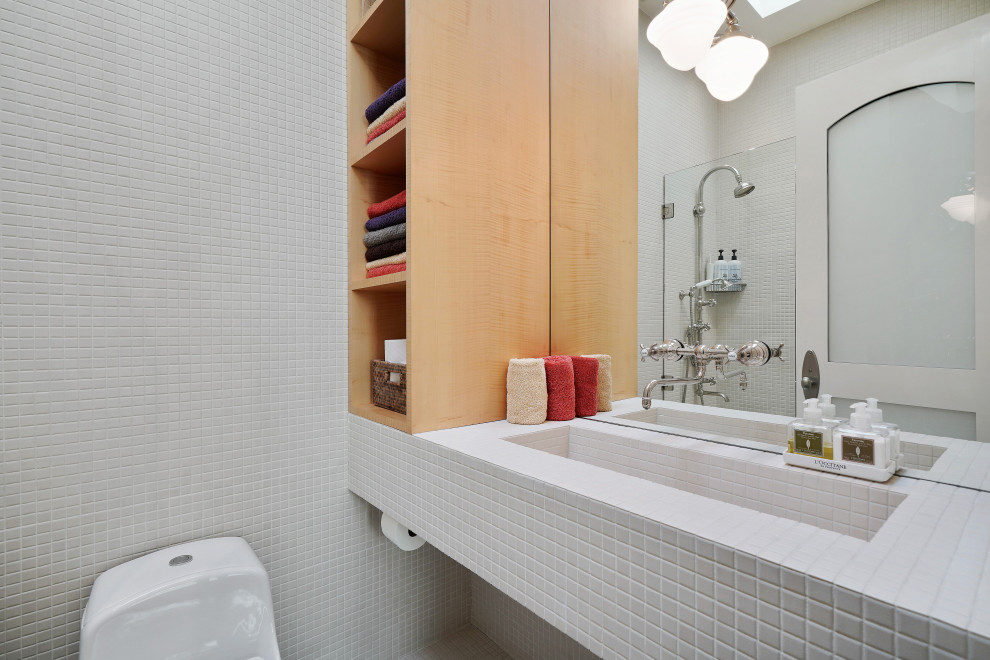 Photo of a mid-sized eclectic kids bathroom in San Francisco with open cabinets, white cabinets, a shower/bathtub combo, a one-piece toilet, white tile, ceramic tile, white walls, ceramic floors, an integrated sink, tile benchtops, white floor, an open shower and white benchtops.