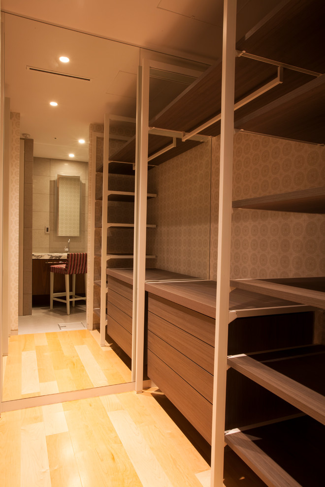 This is an example of a large contemporary walk-in wardrobe in Other with open cabinets, brown cabinets and beige floor.