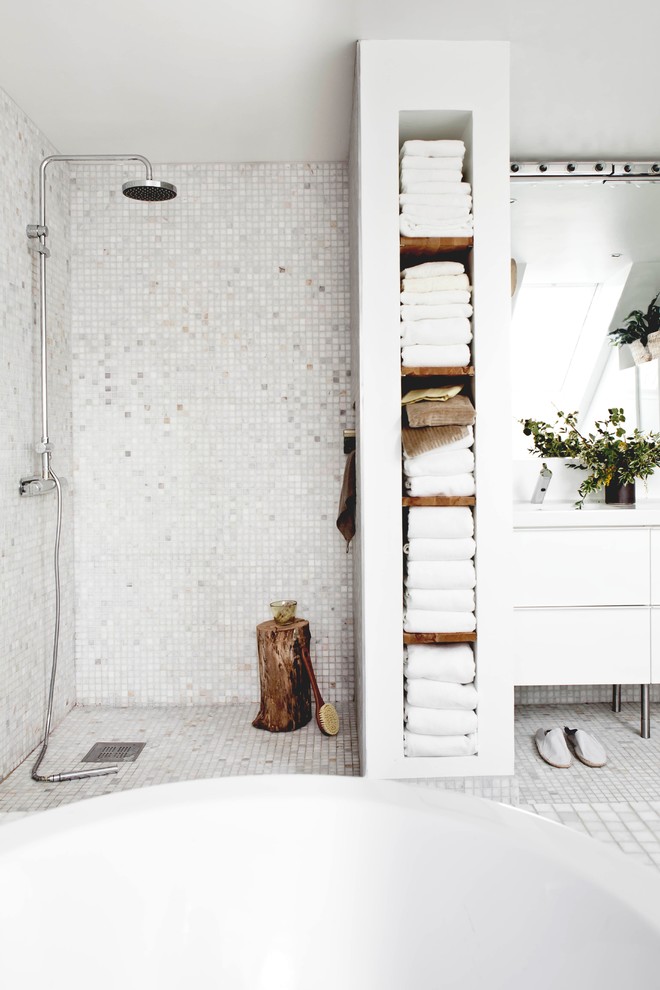 This is an example of a scandinavian bathroom in Malmo with white tile, white walls and a curbless shower.