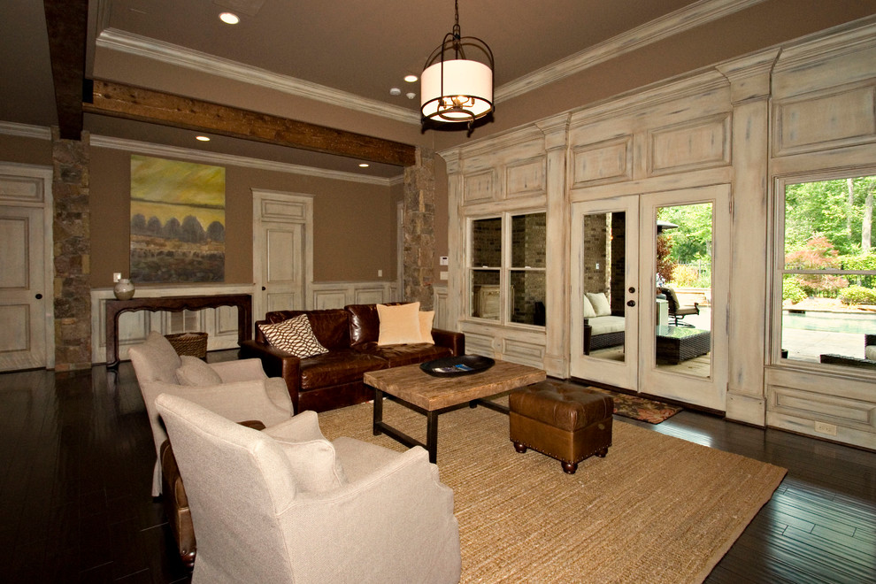This is an example of a country open concept living room in Atlanta with beige walls, dark hardwood floors and a wall-mounted tv.