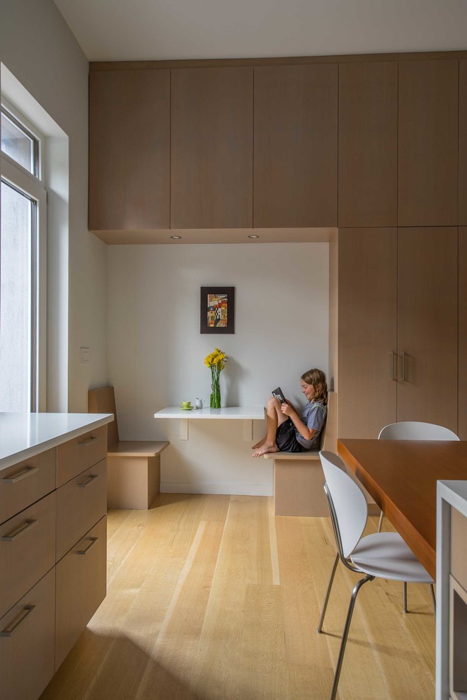 Eat-in kitchen - mid-sized modern medium tone wood floor eat-in kitchen idea in Boston with flat-panel cabinets, light wood cabinets, quartz countertops, an island and white countertops