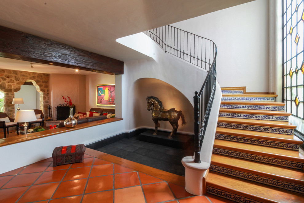 Design ideas for a wood curved staircase in Mexico City with tile risers and metal railing.