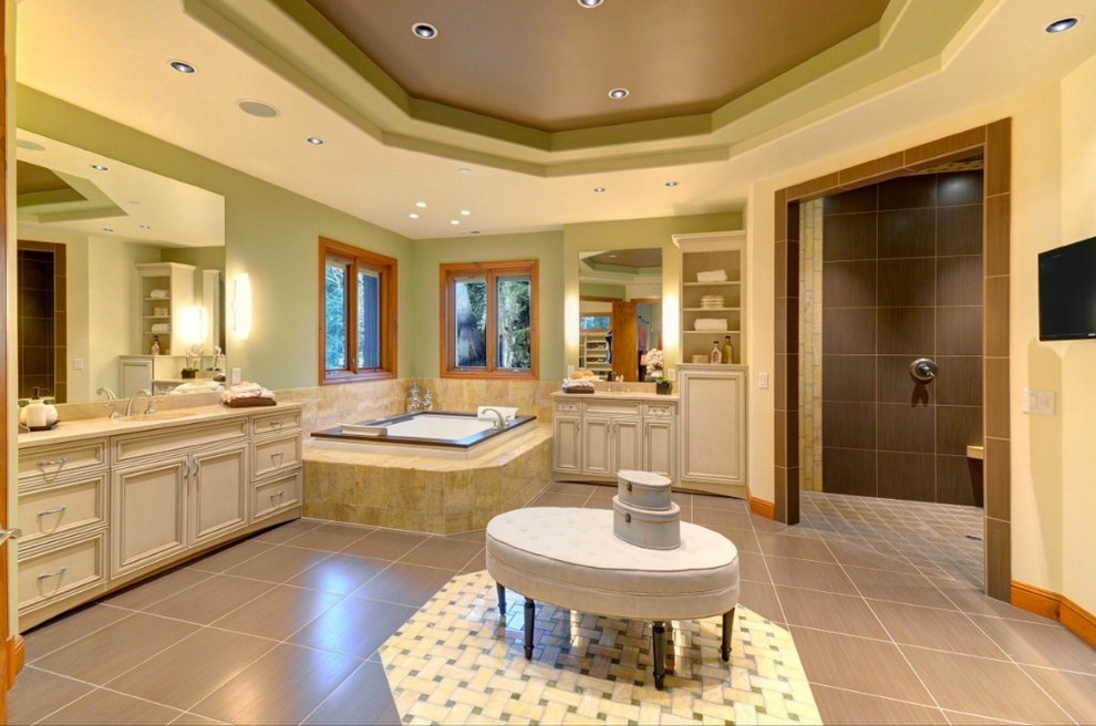 This is an example of an expansive traditional master bathroom in Seattle with beaded inset cabinets, beige cabinets, a drop-in tub, a corner shower, brown tile, porcelain tile, green walls, porcelain floors, an undermount sink, granite benchtops, grey floor and an open shower.