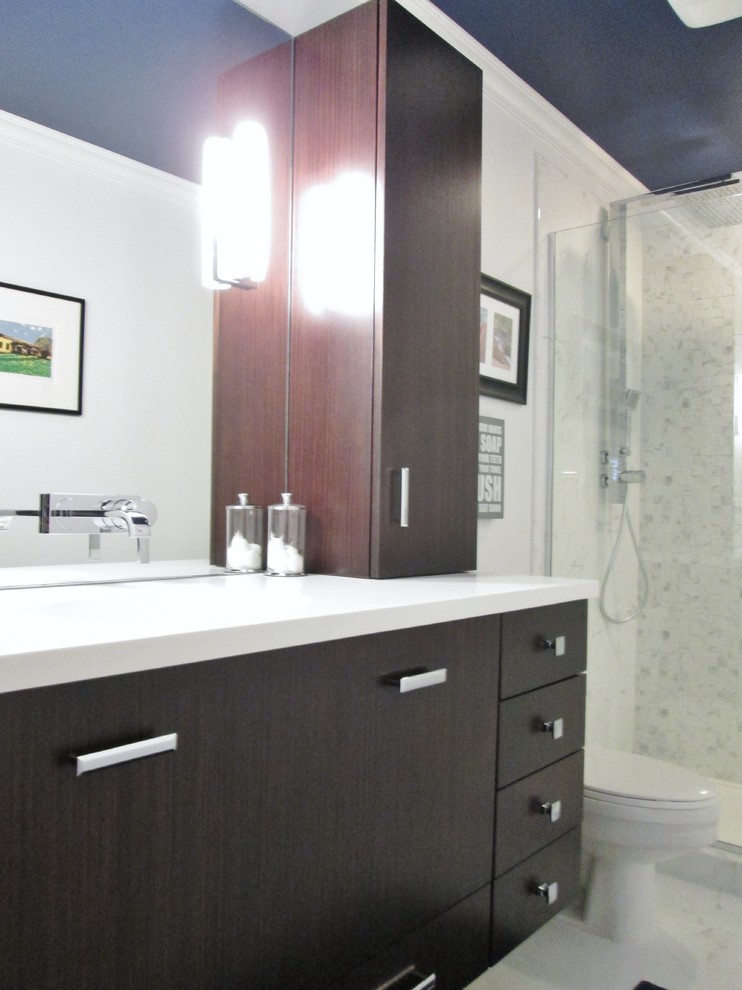 Bathroom - small transitional 3/4 white tile white floor bathroom idea in Chicago with flat-panel cabinets, dark wood cabinets, a one-piece toilet, white walls, an integrated sink and solid surface countertops