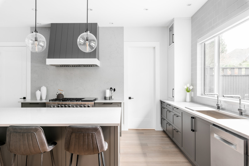 Example of a large transitional u-shaped open concept kitchen design in Vancouver with shaker cabinets, gray cabinets and an island