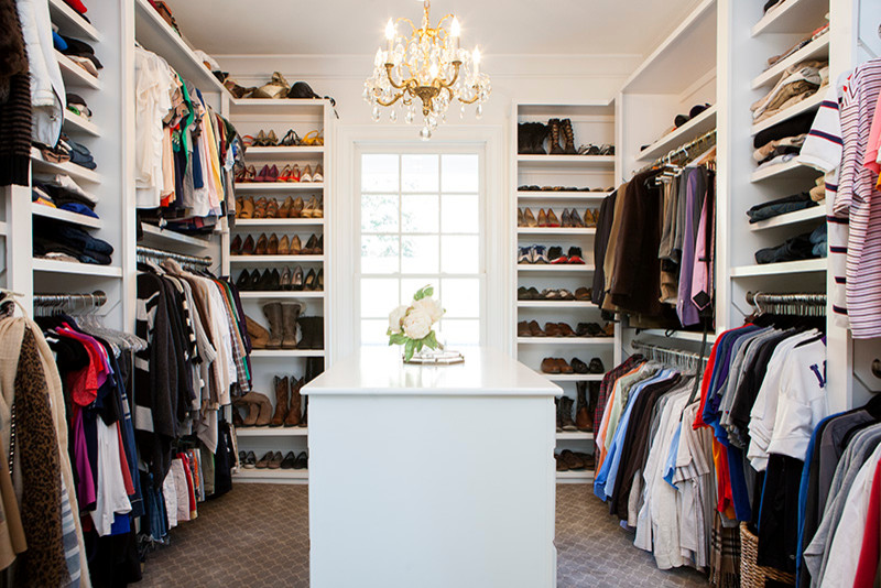 This is an example of a mid-sized traditional gender-neutral walk-in wardrobe in Nashville with open cabinets, white cabinets, carpet and brown floor.