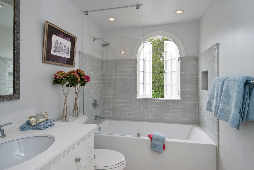 Photo of a traditional bathroom in San Francisco with a shower/bathtub combo and white benchtops.