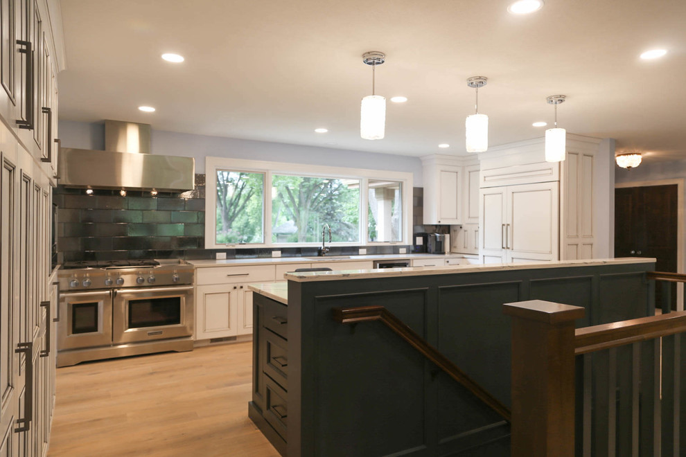 Mid-sized transitional u-shaped light wood floor and beige floor eat-in kitchen photo with an undermount sink, recessed-panel cabinets, white cabinets, quartzite countertops, black backsplash, porcelain backsplash, stainless steel appliances, an island and white countertops