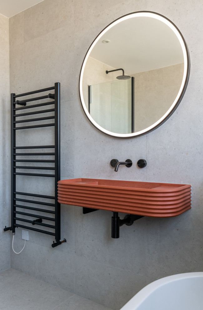 Inspiration for a mid-sized contemporary kids bathroom in London with a freestanding tub, an open shower, a one-piece toilet, gray tile, porcelain tile, grey walls, porcelain floors, a wall-mount sink, concrete benchtops, grey floor, a hinged shower door, orange benchtops and a single vanity.