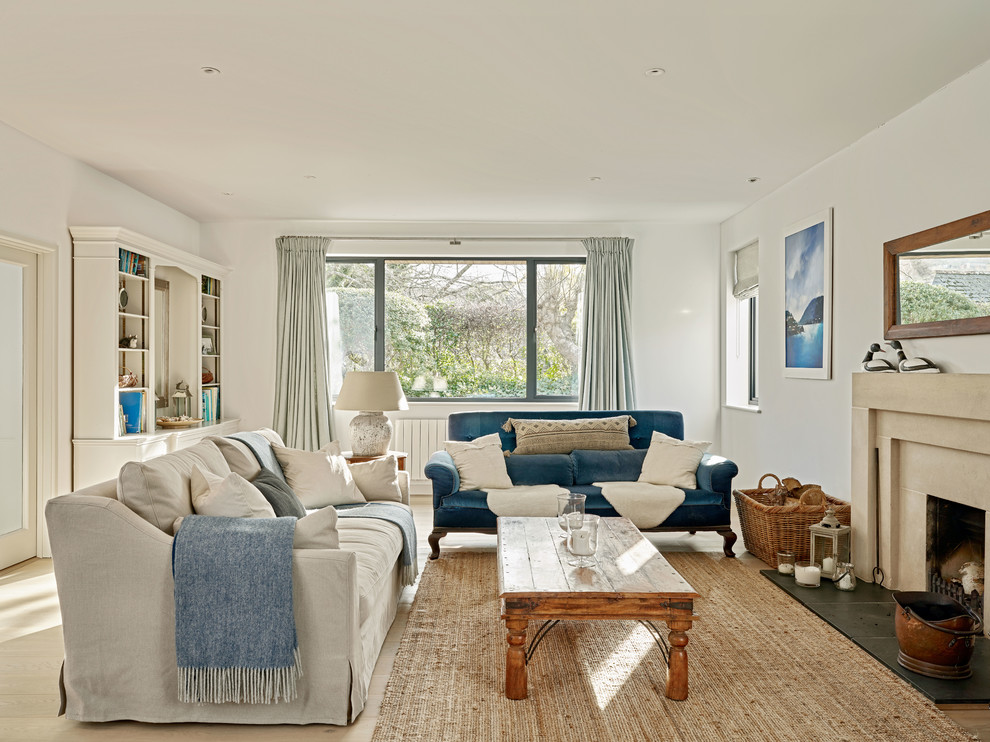 Inspiration for a medium sized nautical living room in Devon with light hardwood flooring, a standard fireplace, beige floors, white walls, a concrete fireplace surround and no tv.