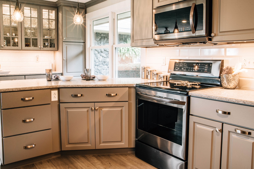 Mid-sized transitional u-shaped medium tone wood floor and brown floor eat-in kitchen photo with a double-bowl sink, raised-panel cabinets, gray cabinets, granite countertops, white backsplash, ceramic backsplash, stainless steel appliances, a peninsula and gray countertops