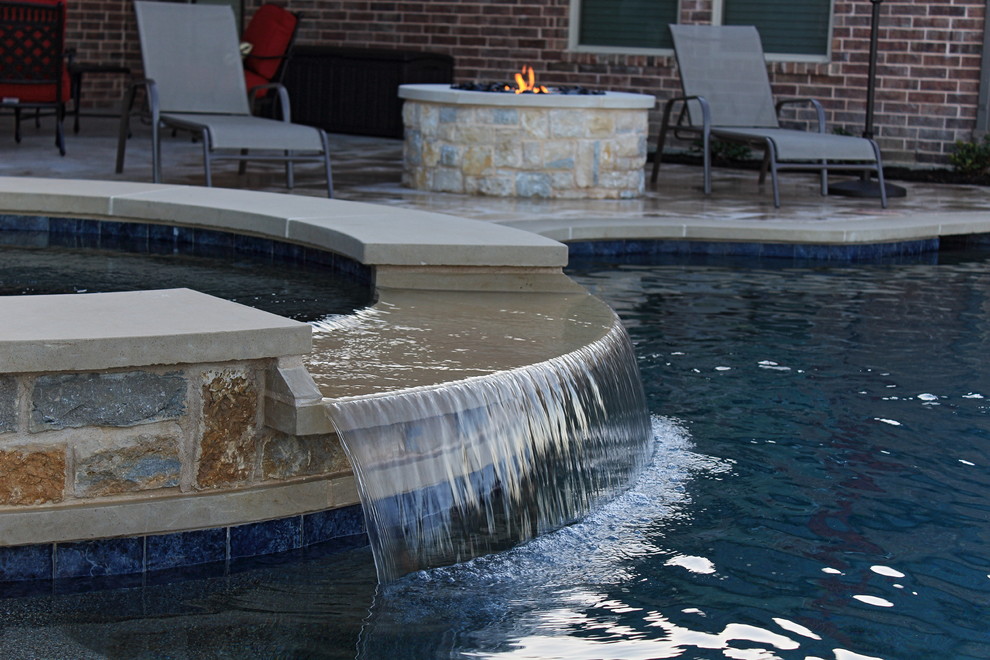 Photo of a mid-sized country backyard custom-shaped infinity pool in Dallas with natural stone pavers.