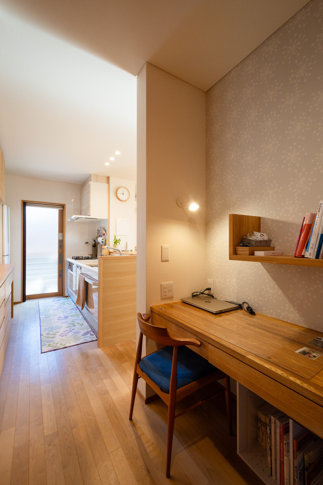 Imagen de despacho blanco de tamaño medio sin chimenea con paredes blancas, suelo de madera clara, papel pintado y papel pintado