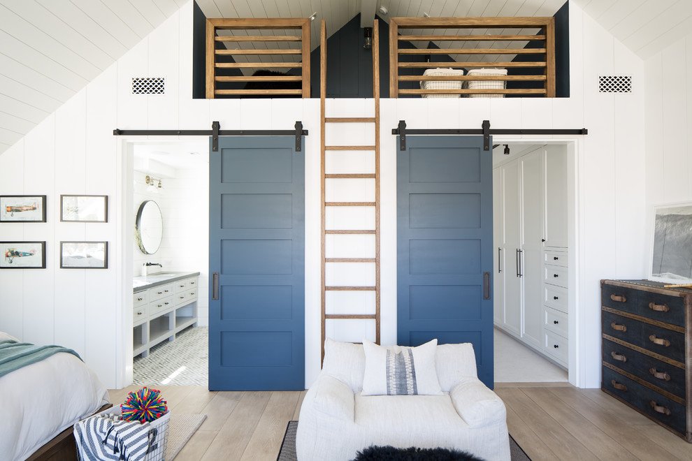 This is an example of a beach style gender-neutral kids' bedroom in Orange County with white walls, medium hardwood floors and brown floor.