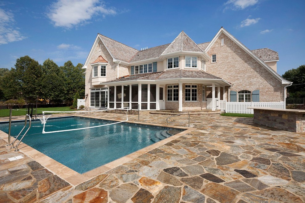 Inspiration for a large traditional backyard rectangular lap pool in Chicago with natural stone pavers.
