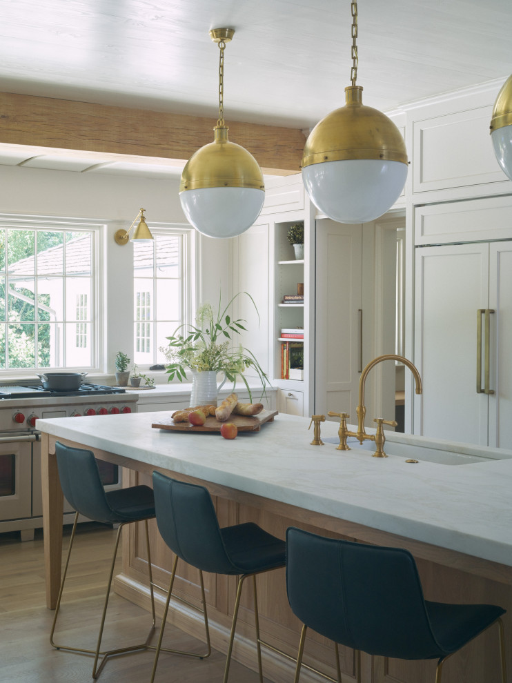 Design ideas for a transitional kitchen in Birmingham with recessed-panel cabinets, white cabinets, marble benchtops, white appliances, medium hardwood floors, with island, white benchtop, an undermount sink and brown floor.