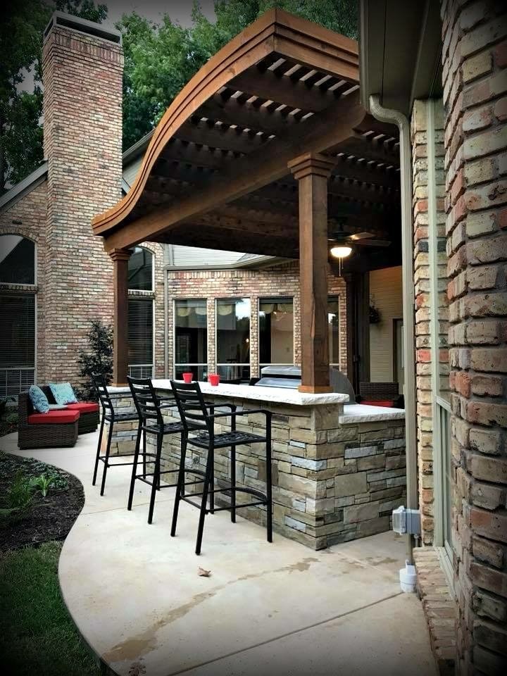 This is an example of a traditional backyard patio in Dallas with an outdoor kitchen, concrete slab and a pergola.