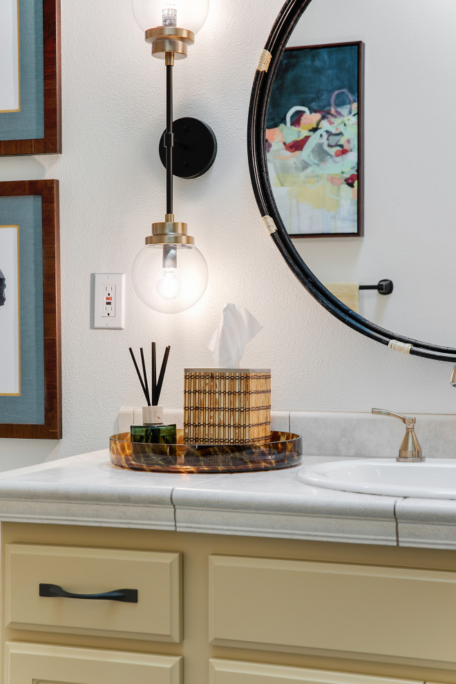 Стильный дизайн: ванная комната среднего размера в стиле фьюжн с фасадами с выступающей филенкой, желтыми фасадами, ванной в нише, душем над ванной, унитазом-моноблоком, разноцветной плиткой, керамической плиткой, белыми стенами, полом из керамогранита, душевой кабиной, накладной раковиной, столешницей из плитки, разноцветным полом, шторкой для ванной, бежевой столешницей, тумбой под одну раковину, встроенной тумбой и сводчатым потолком - последний тренд