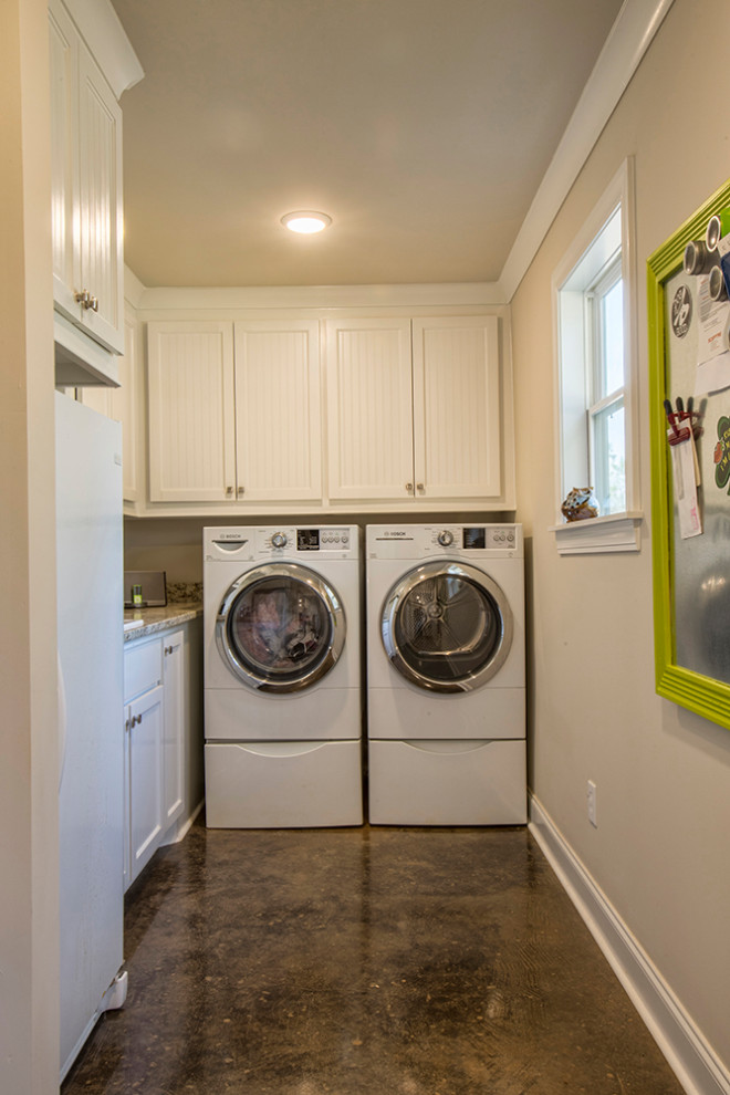 Inspiration for a small country l-shaped dedicated laundry room in Other with a drop-in sink, shaker cabinets, white cabinets, granite benchtops, beige walls, concrete floors, a side-by-side washer and dryer, black floor and beige benchtop.