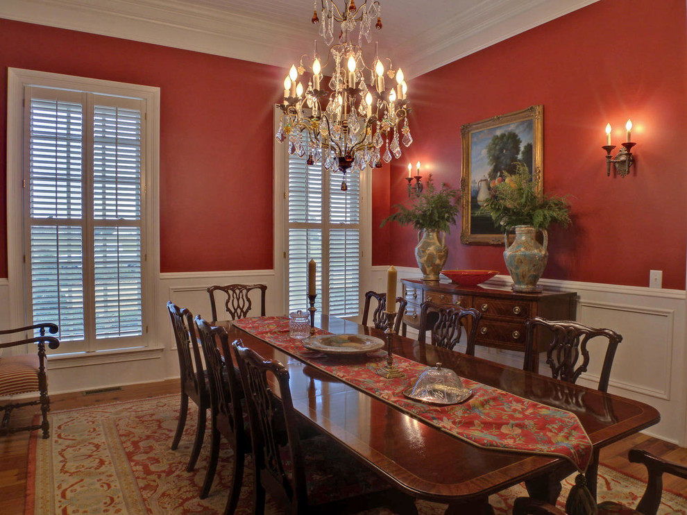 This is an example of a large traditional separate dining room in Atlanta with red walls and medium hardwood floors.
