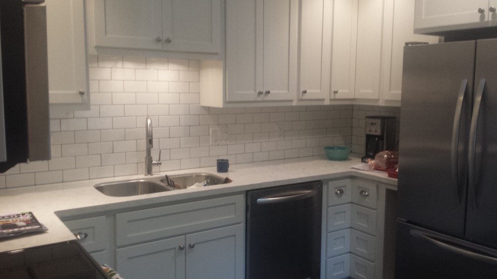 Inspiration for an u-shaped eat-in kitchen remodel with an undermount sink, shaker cabinets, white cabinets, white backsplash, subway tile backsplash and stainless steel appliances
