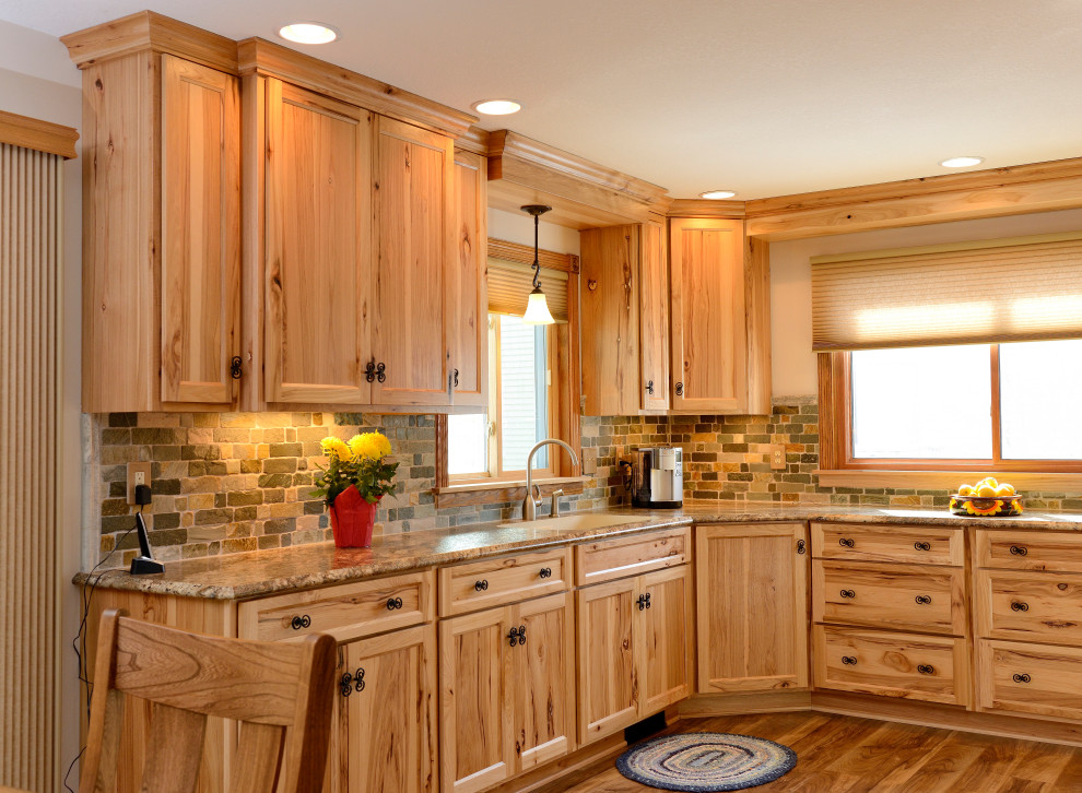 Large country u-shaped eat-in kitchen in Minneapolis with an integrated sink, shaker cabinets, light wood cabinets, laminate benchtops, green splashback, stone tile splashback, white appliances, laminate floors, brown floor and multi-coloured benchtop.